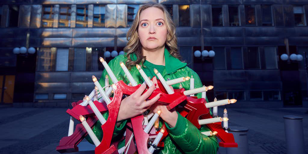 Kvinna med famnen full av jul ljusstakar